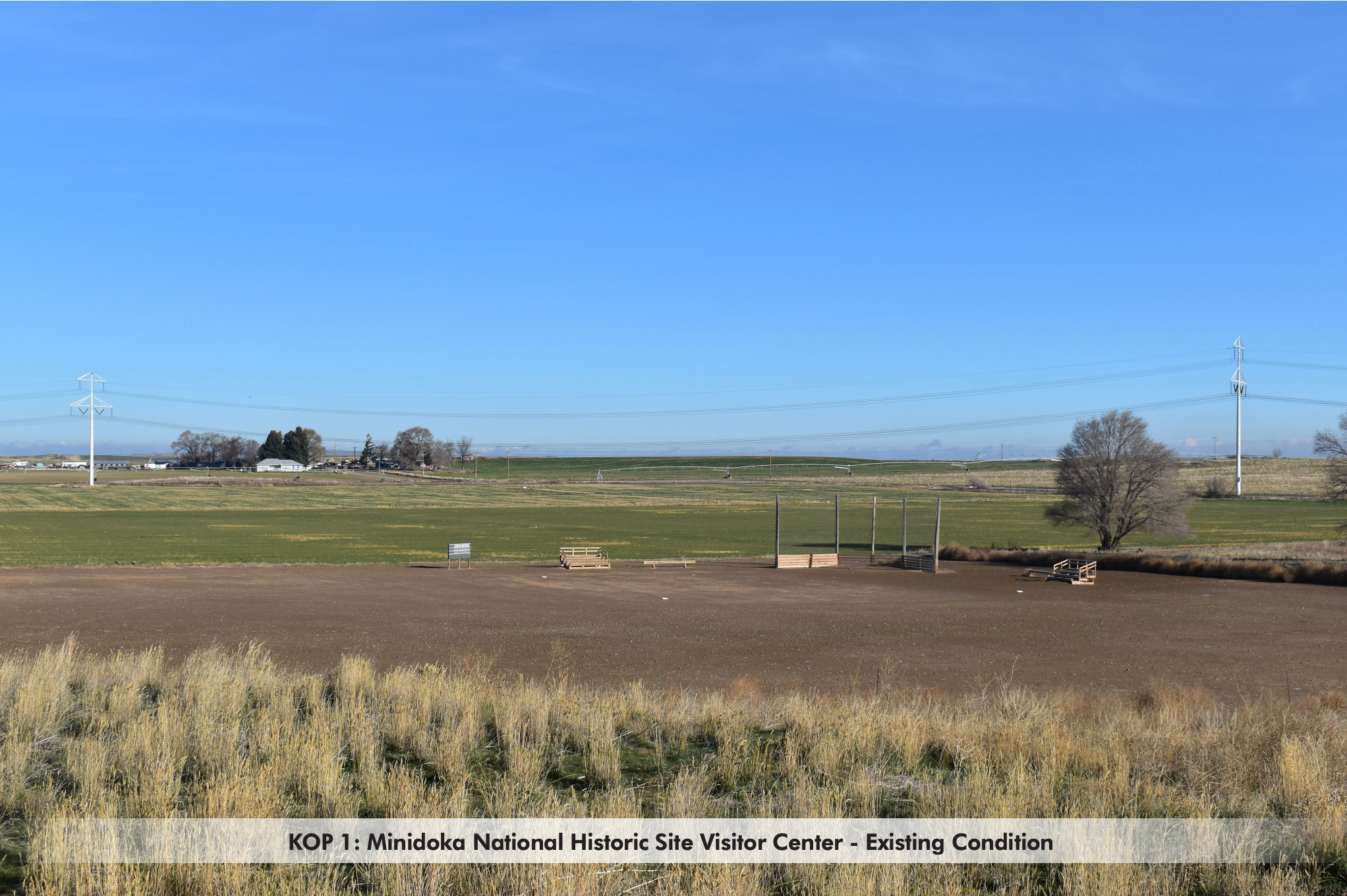 Photograph of the view from the Minidoka National Historic Site visitor center: open farmland, a dirt ballfield, and transmission poles under a blue sky. Labeled: existing condition.